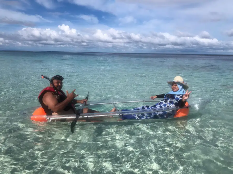 Sea kayaking through calm sheltered waters near Blue Ocean Resort, Semporna Sabah